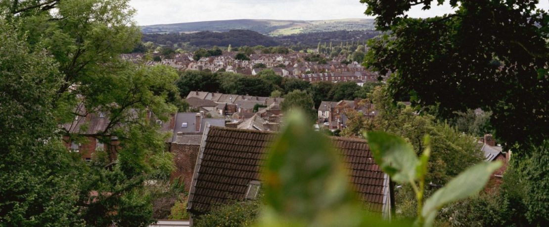 A view over rooftops with hills visible behind