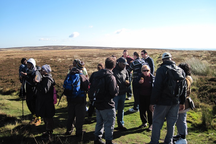 A diverse group of people enjoying refreshments on an upland walk