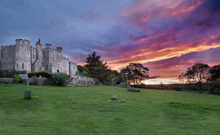 A stately home building against a radiant colourful sunset