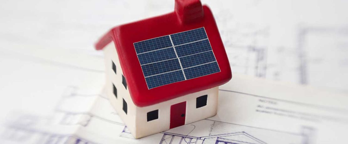 A toy home with small solar panels on the roof