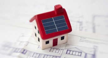 A toy home with small solar panels on the roof