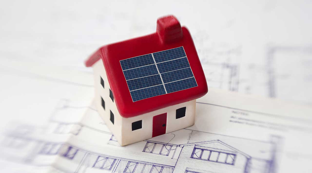 A toy home with small solar panels on the roof