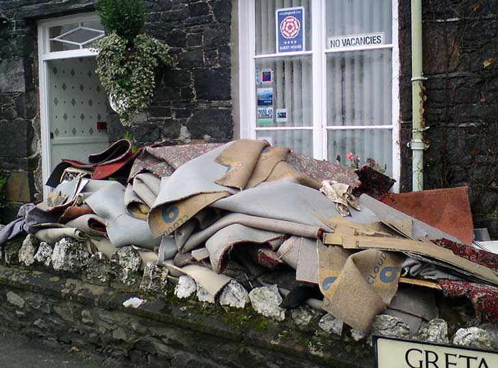 A pile of damaged carpet outside a guest house