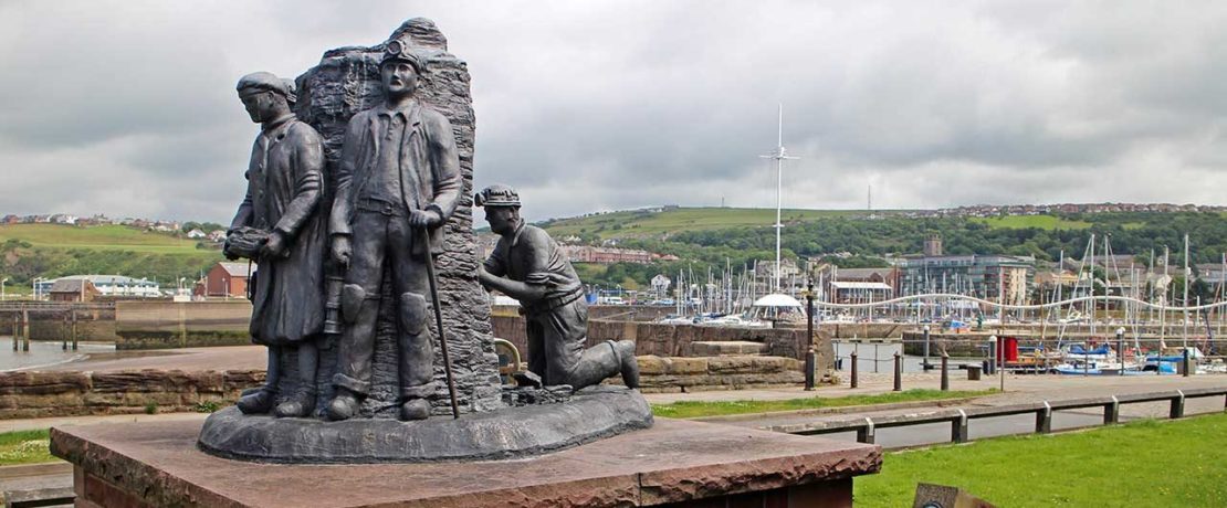 A statue showing three miners