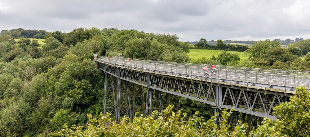 An iron viaduct stretching across a green valley