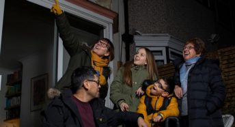 Family star gazing in garden.