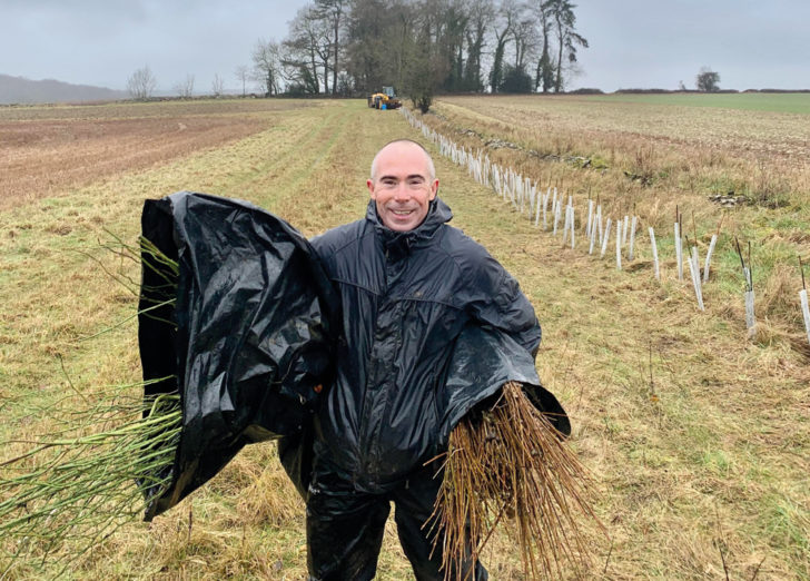 A volunteer in Gloucestershire holding bare root hedge plants