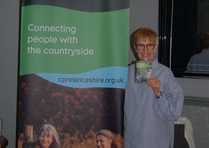Woman stood in front of CPRE banner holding leaflet