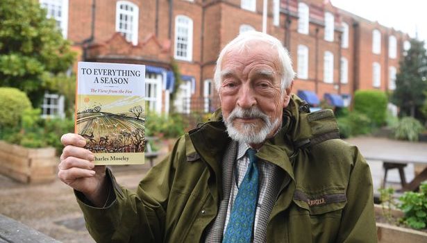 Charles Moseley holding his book at the launch in Cambridge