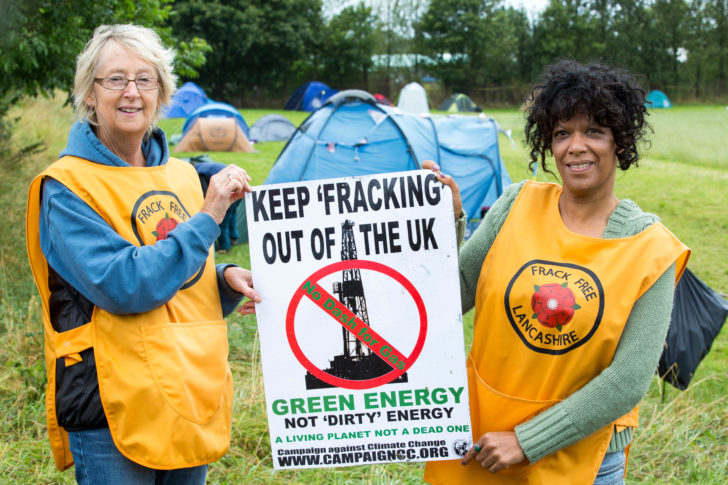 Protestors with a protest banner against fracking at a farm site at Little Plumpton near Blackpool