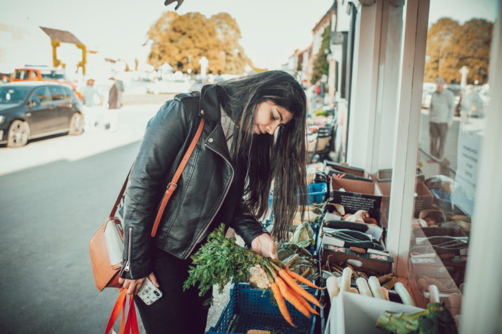 Woman looking at food outside village shop 