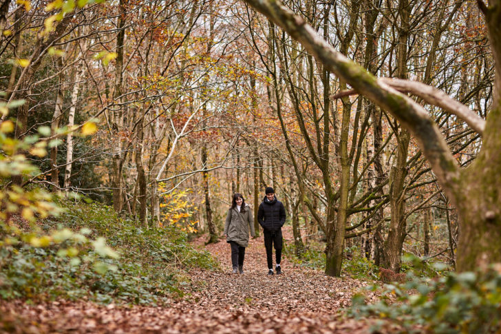 Woman and man walking through woodland