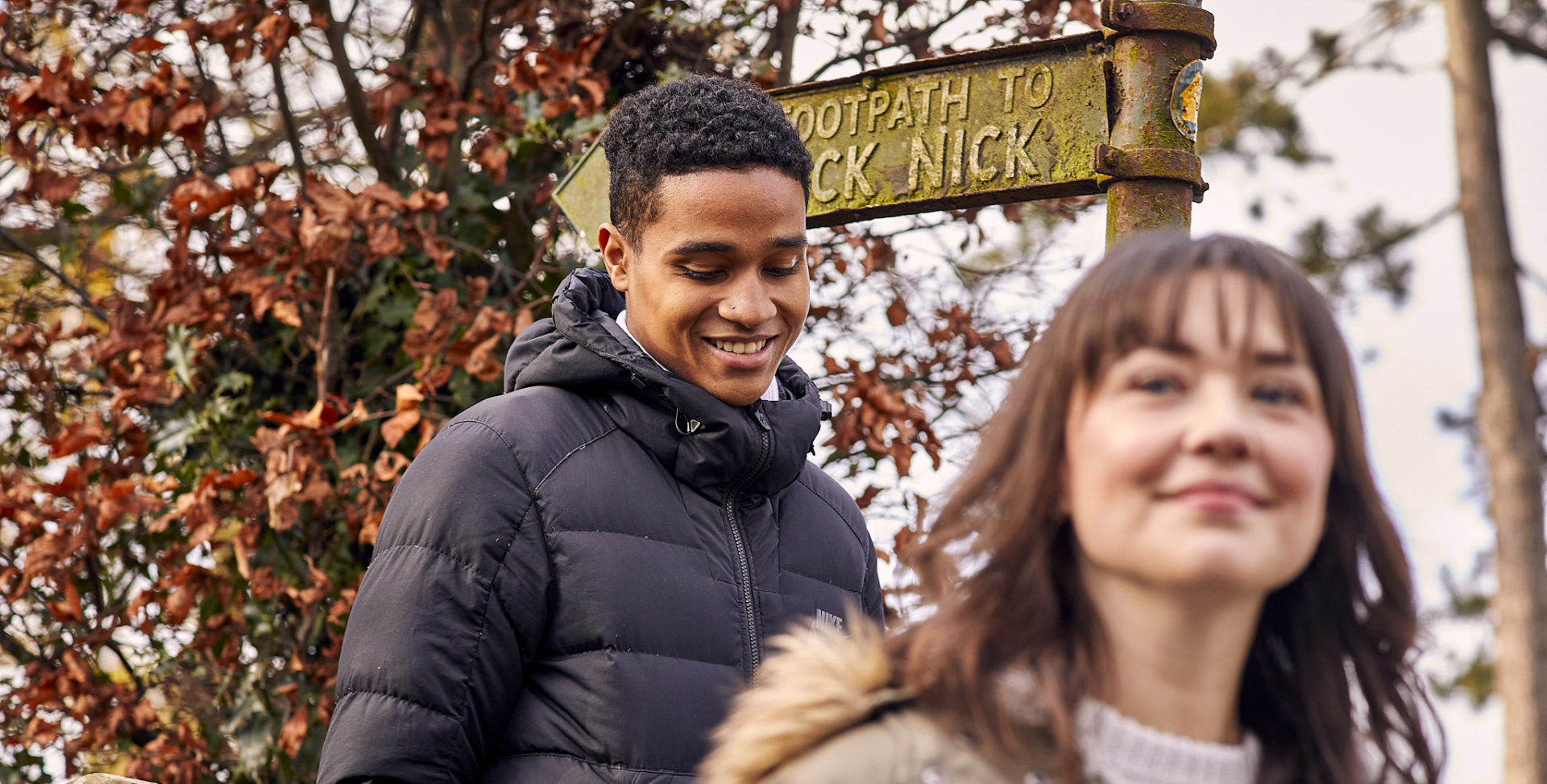 Close up of woman and man near footpath sign