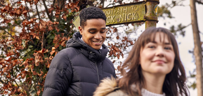 Close up of woman and man near footpath sign