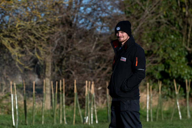 Man stood next to planted hedgerow whips