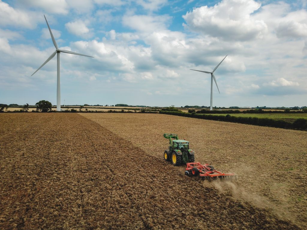 Farmland with wind turbines in background