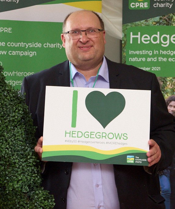 CPRE Derbyshire's John Ydlibi holding a "I Love Hedgerows" sign