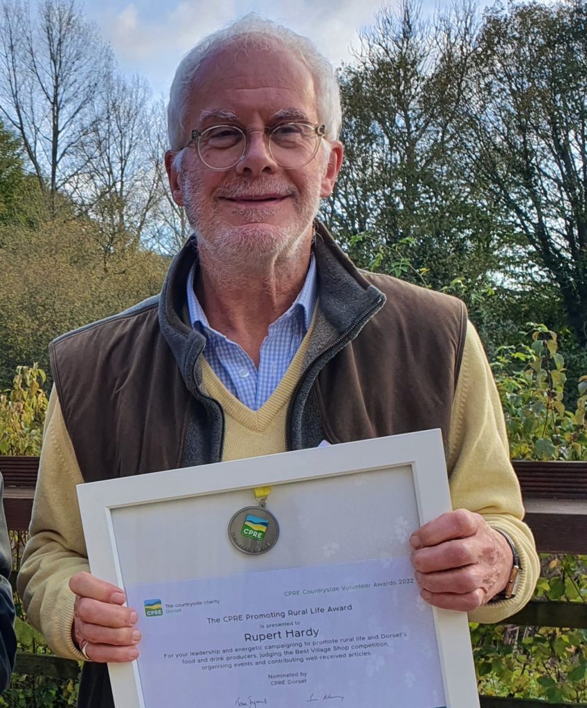 Rupert Hardy holding his trustee award