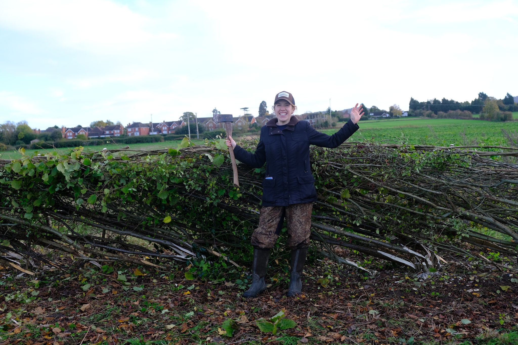 A woman stood in front of a laid hedgerow