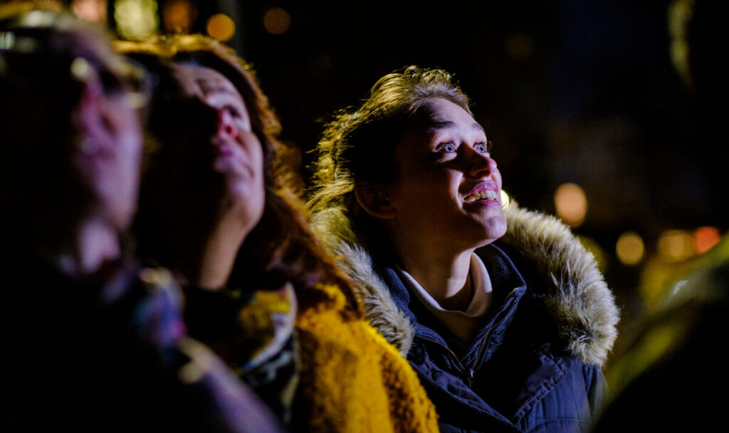 Woman looking up at the sky smiling brightly