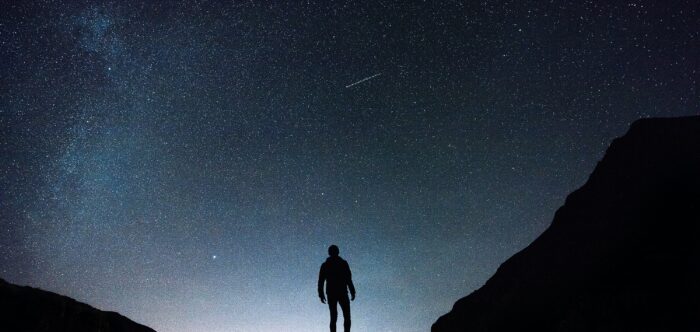Silhouette looking out at night sky