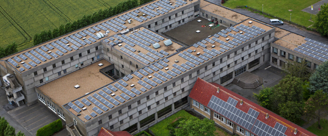 Photovoltaic solar panels on roof providing electricity by sun energy to office buildings