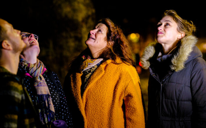 Group of friends looking up at the sky smiling in amazement