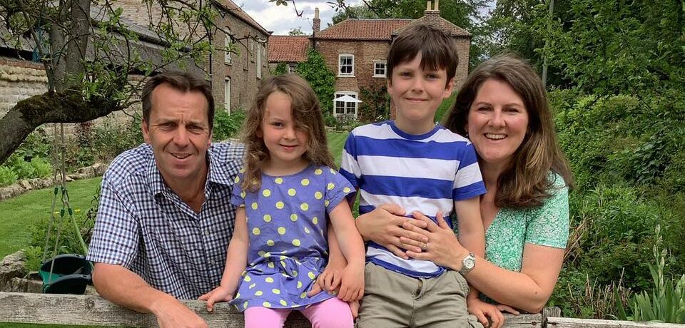 Emma, Robert and family leaning over garden fence