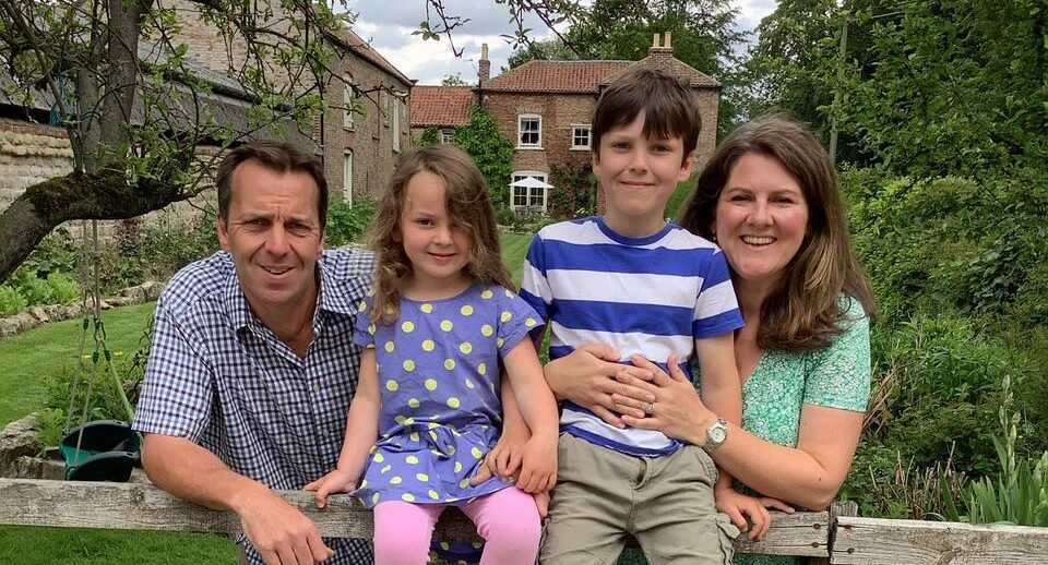 Emma, Robert and family leaning over garden fence