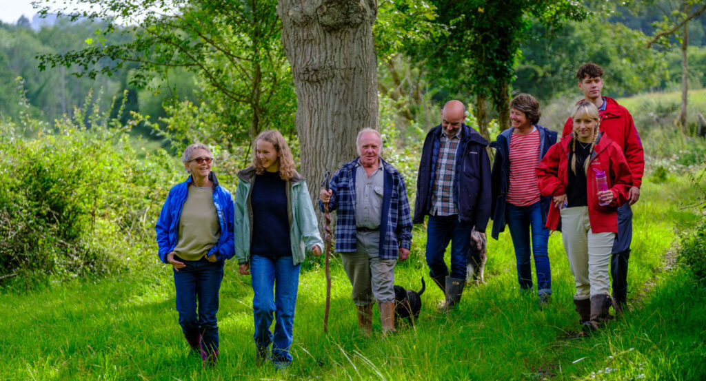 A group of adults taking a walk through a farm field in Sussex