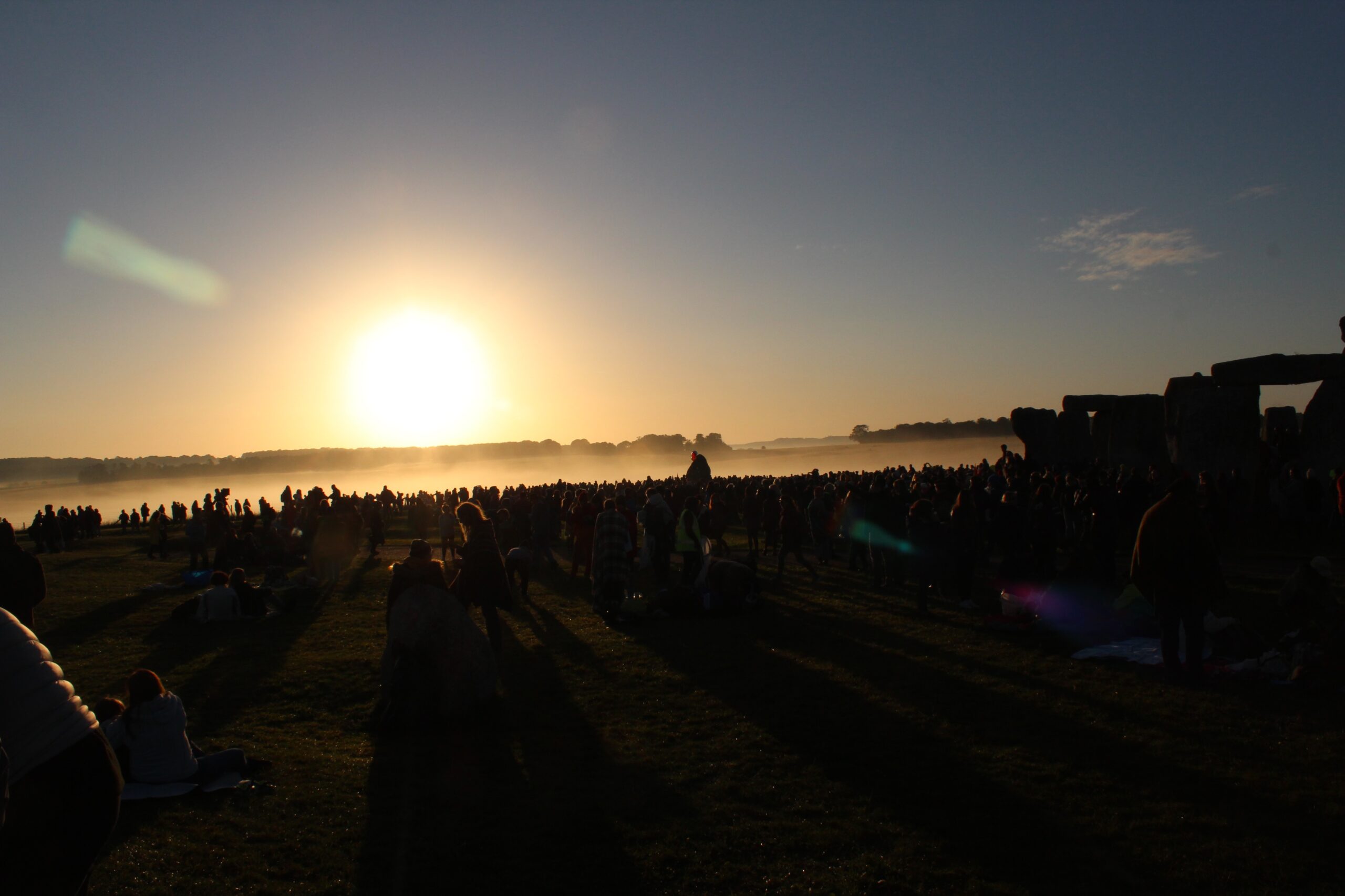 A crowd of people silhouetted against the sunset