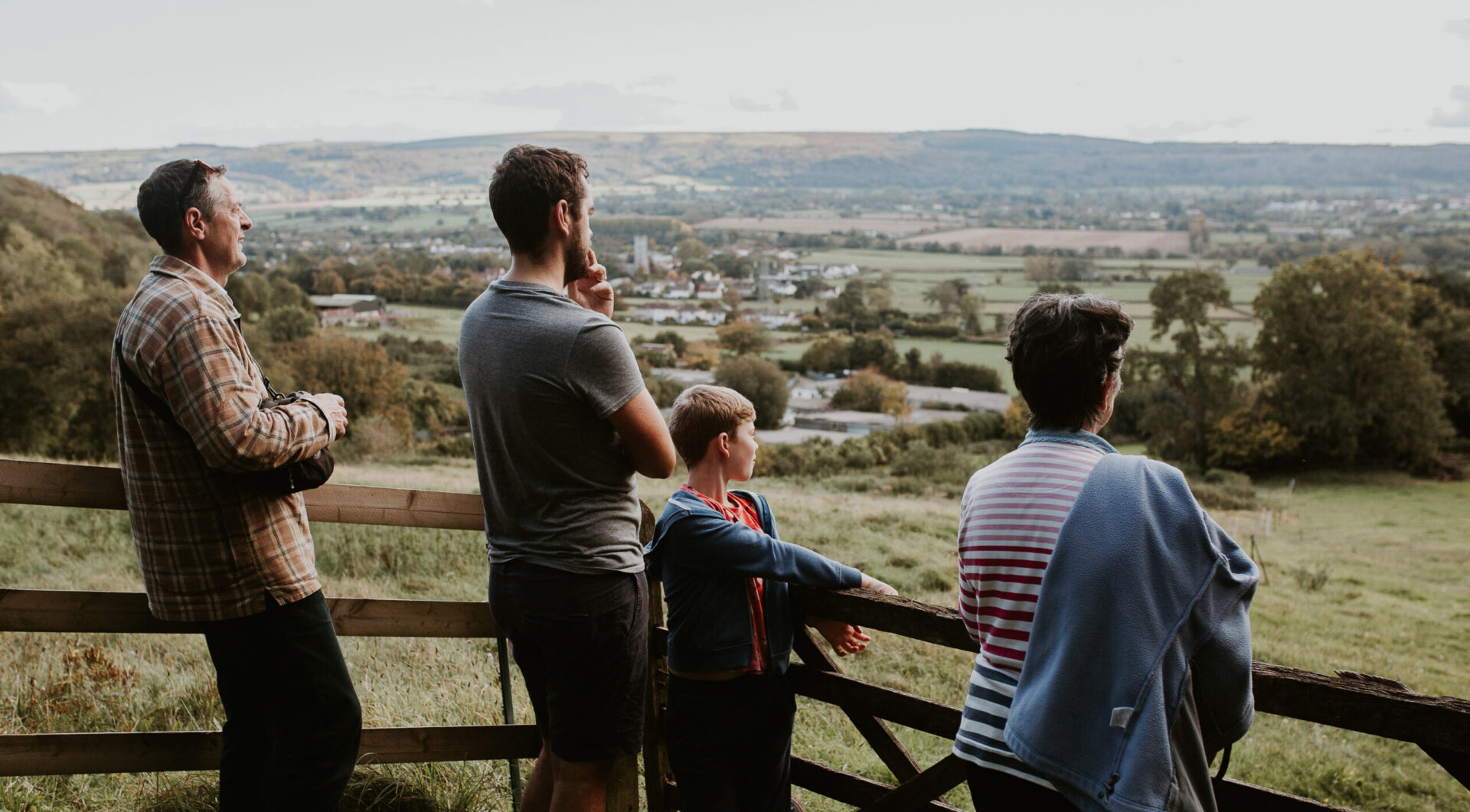 Family photos on a countryside walk leaning against a wooden gate looking out over the Green Belt