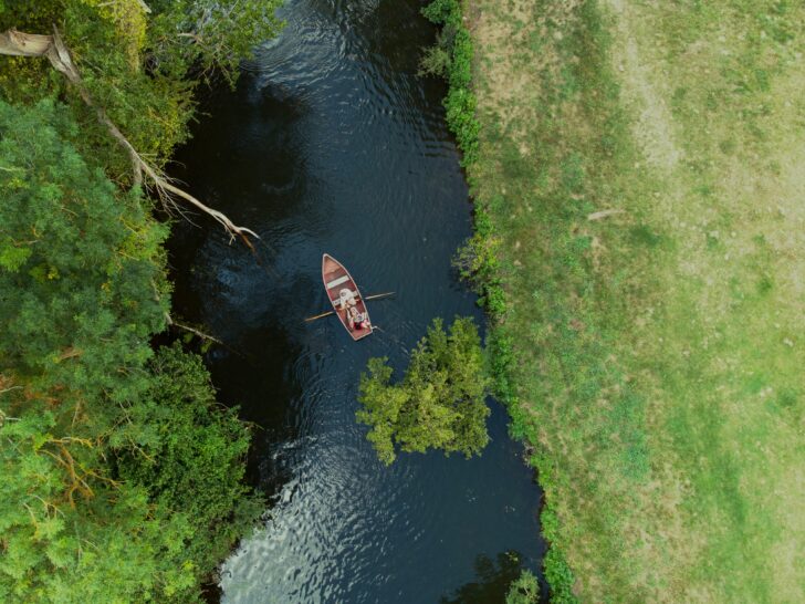 An aerial view of the Dedham Vale AONB with a top down shot of a rowing boat on the river