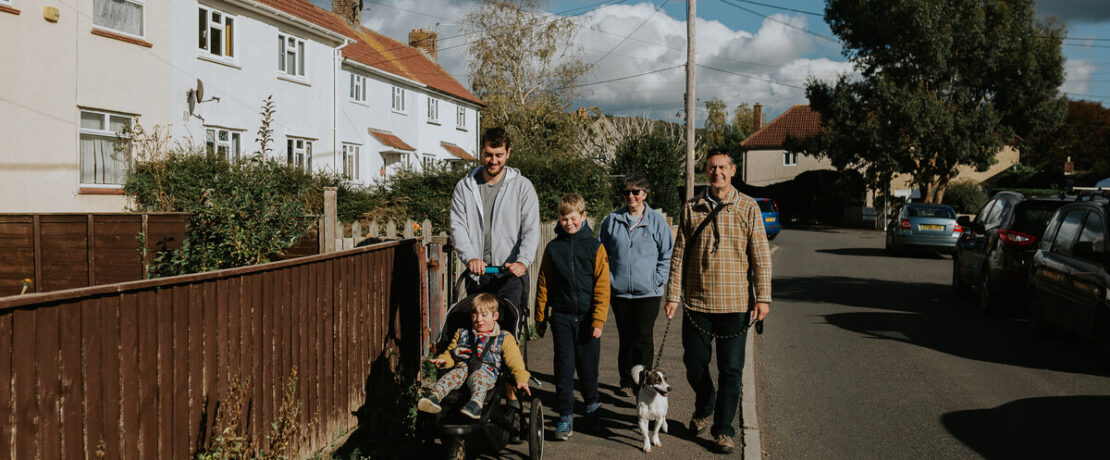 Family walking in a village throgh affordable housing