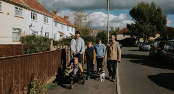 Family walking in a village throgh affordable housing