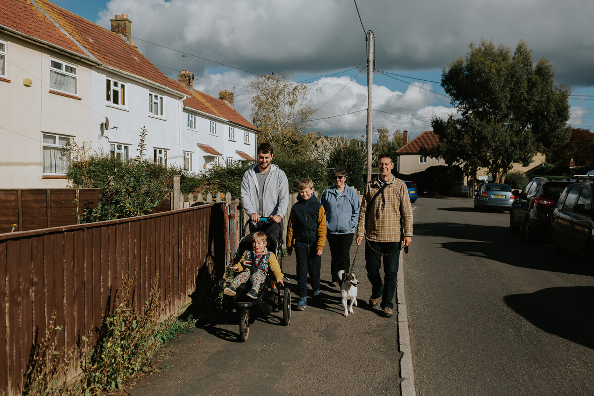 Family walking in a village throgh affordable housing