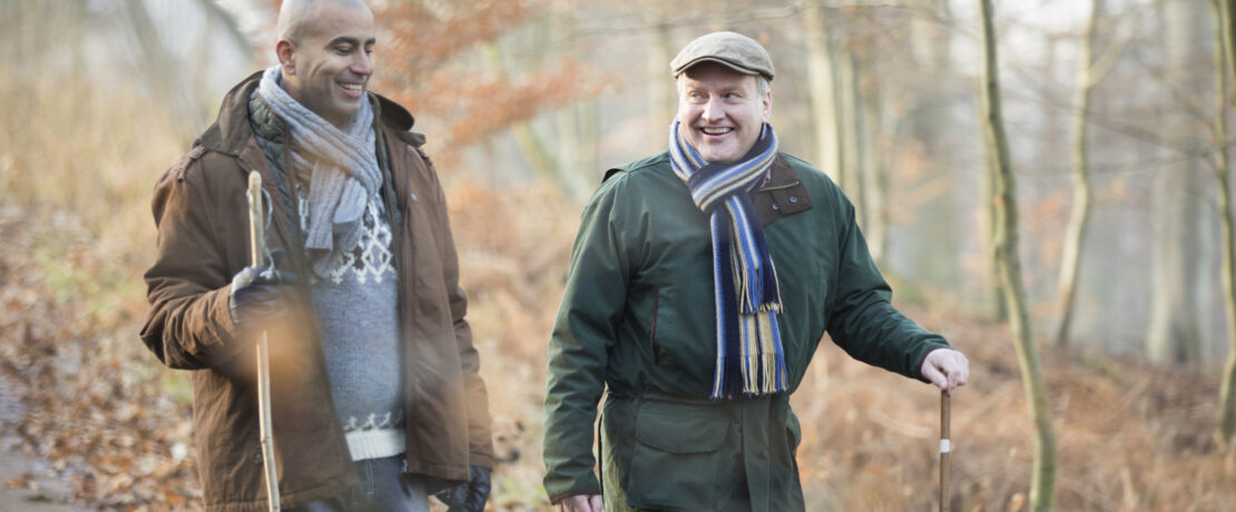 Two friends walking in the woods in autumn