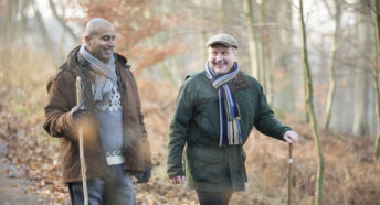 Two friends walking in the woods in autumn