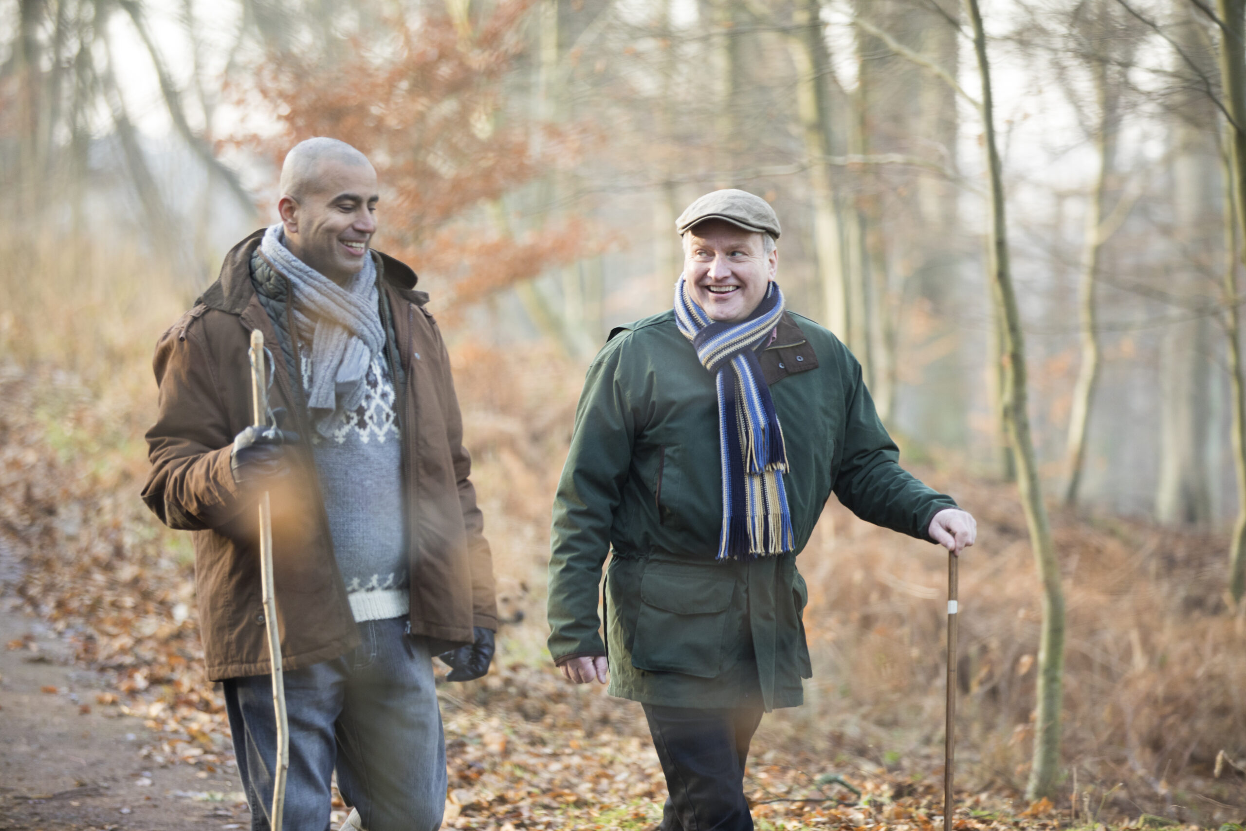 Two friends walking in the woods in autumn