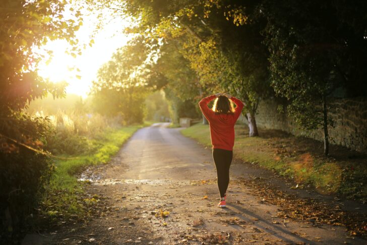 Woman taking peaceful walk down country lane