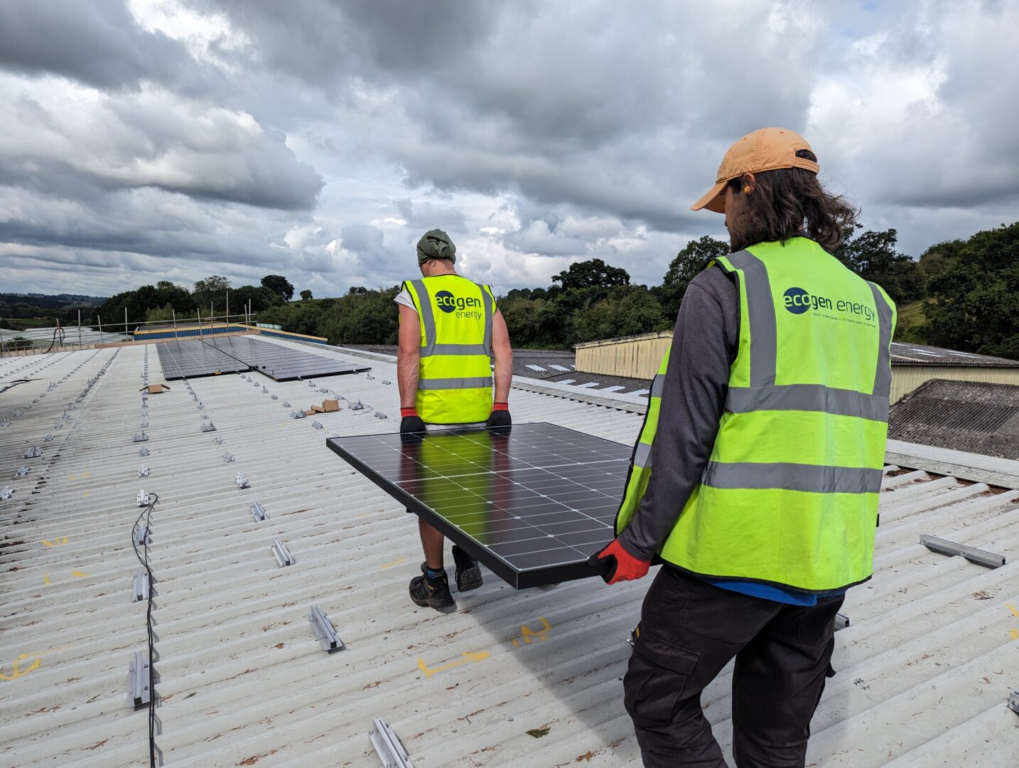 Ecogen Energy team carrying solar panels on roof