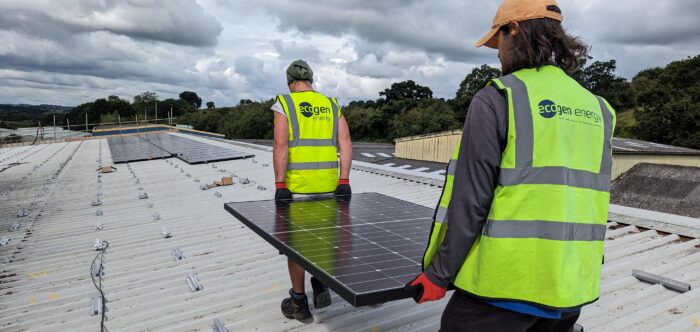 Ecogen Energy team carrying solar panels on roof