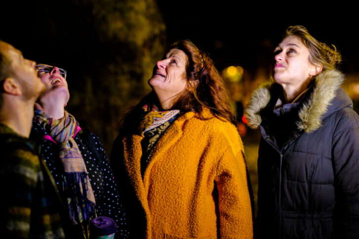 Group of friends looking up at the sky smiling in amazement