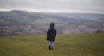 A child walking on a field in Hyde, near Manchester