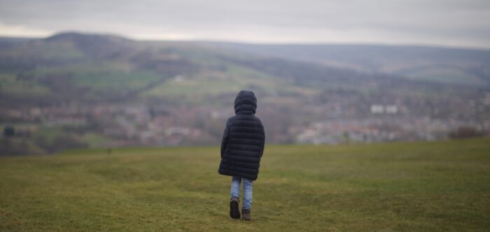 A child walking on a field in Hyde, near Manchester