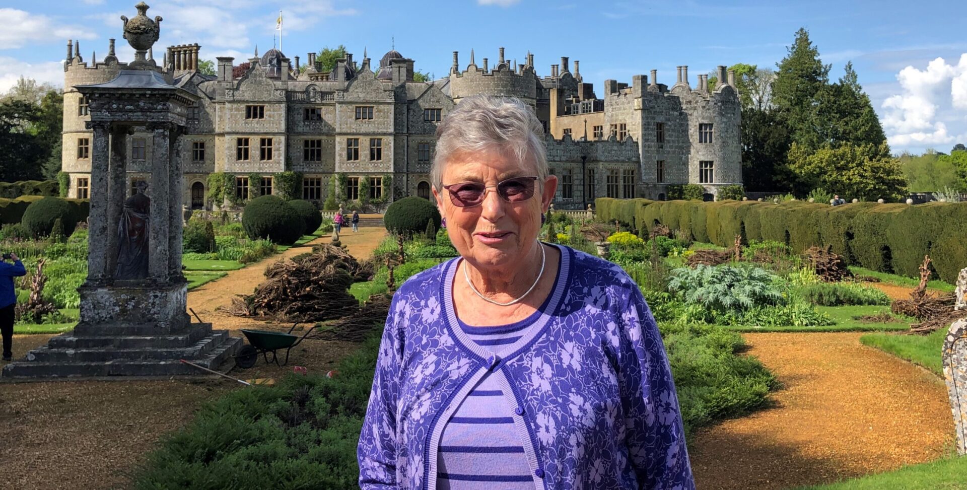 A woman stood outside an historic home in the countryside