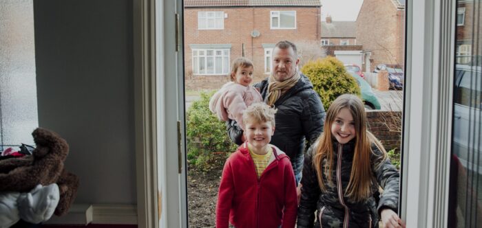 Family walking through the front door of a house