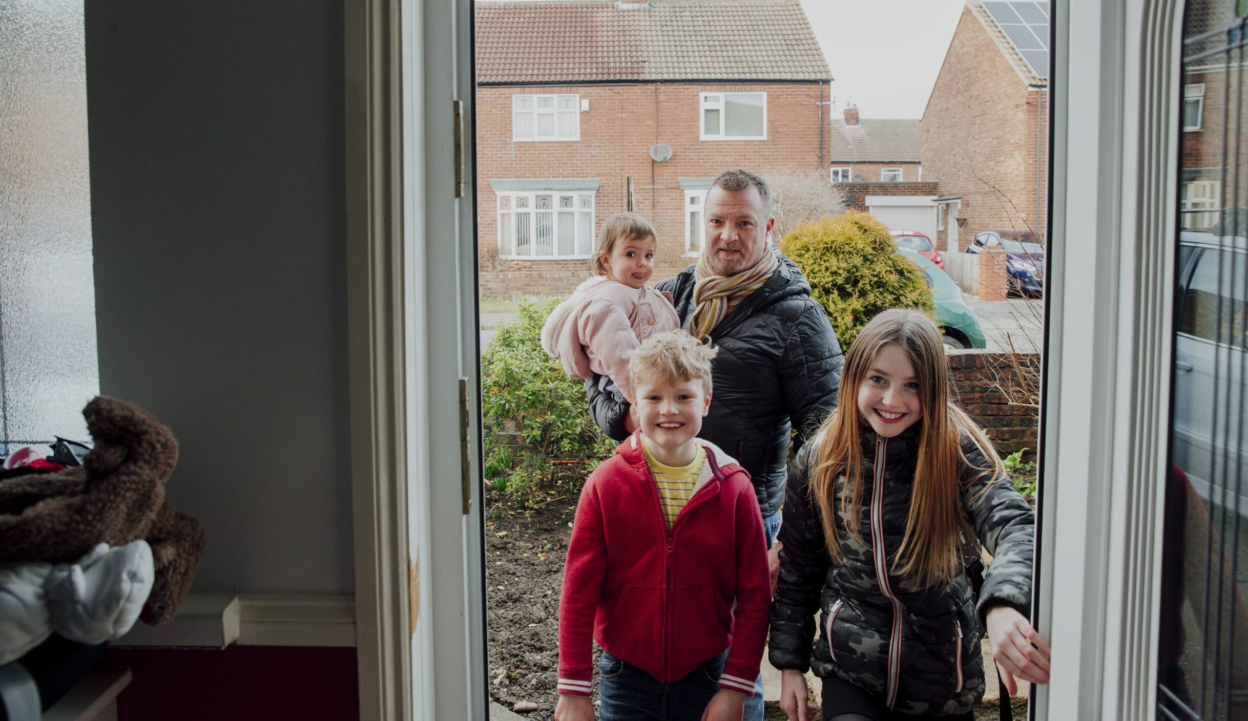 Family walking through the front door of a house
