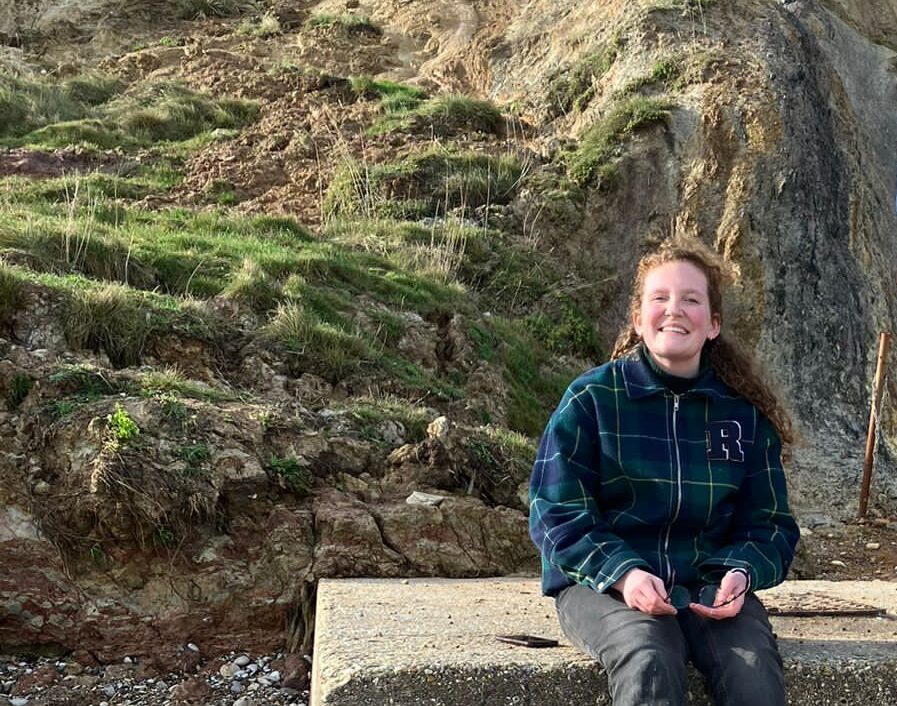 Photo of Jasmine sat in the countryside