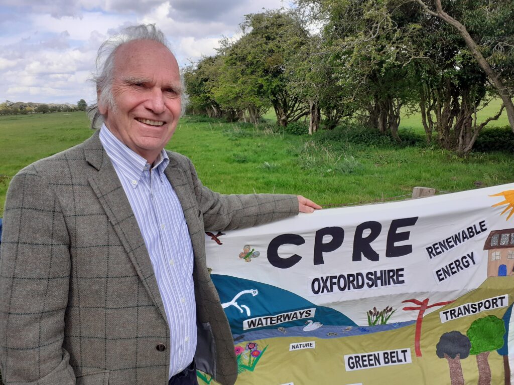 Richard Harding holding a CPRE banner in the countryside